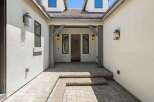 Step into this inviting entryway featuring a charming wooden door flanked by two elegant windows.