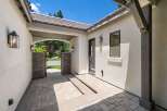 Step into this charming home through a welcoming courtyard featuring elegant stone pillars and a covered walkway.