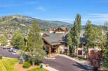 Experience luxury mountain living in this stunning property, featuring a grand entrance with stone accents and warm wood finishes.