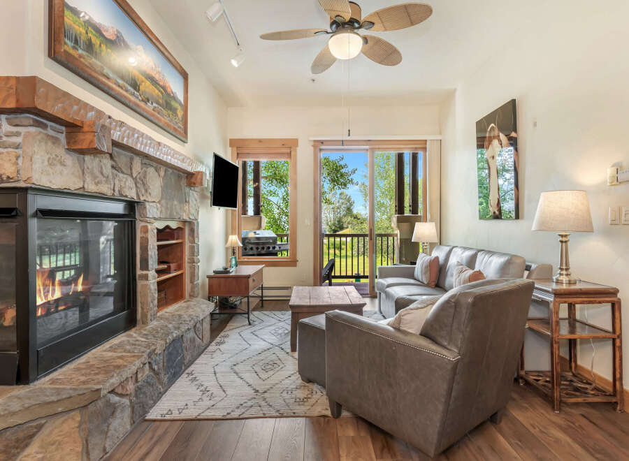 Cozy living room featuring a large stone fireplace with a roaring fire, perfect for chilly evenings.