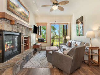 Cozy living room featuring a large stone fireplace with a roaring fire, perfect for chilly evenings.