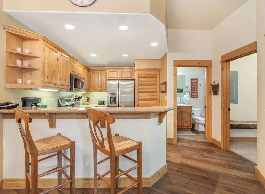 Experience the charm of this inviting kitchen, featuring warm wooden cabinetry and a convenient breakfast bar perfect for casual dining.