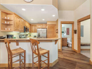 Experience the charm of this inviting kitchen, featuring warm wooden cabinetry and a convenient breakfast bar perfect for casual dining.