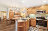 Experience cozy mountain living in this charming kitchen featuring warm wood cabinetry and a spacious granite-topped island perfect for casual dining.