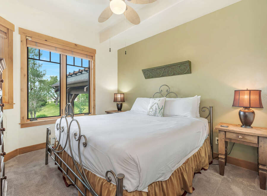 Experience comfort and style in this inviting bedroom, featuring a plush king-sized bed adorned with crisp white linens and a decorative accent pillow.