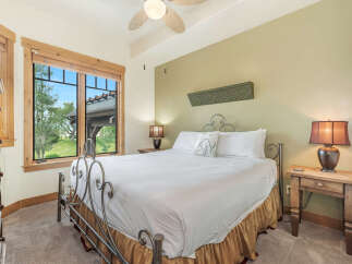 Experience comfort and style in this inviting bedroom, featuring a plush king-sized bed adorned with crisp white linens and a decorative accent pillow.