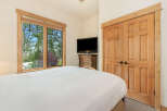 Experience comfort and style in this inviting bedroom, featuring a large window with scenic views and a convenient entertainment center.