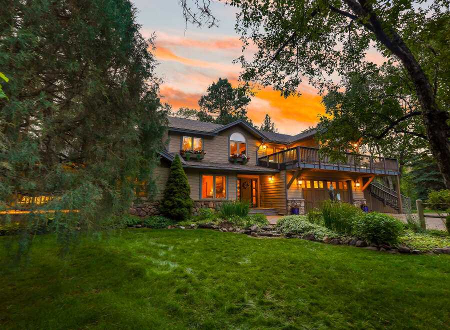 Experience the magic of twilight in this stunning home, nestled amidst lush greenery and mature trees.