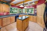 This spacious kitchen boasts custom light wood cabinetry and granite countertops, offering ample storage and workspace.