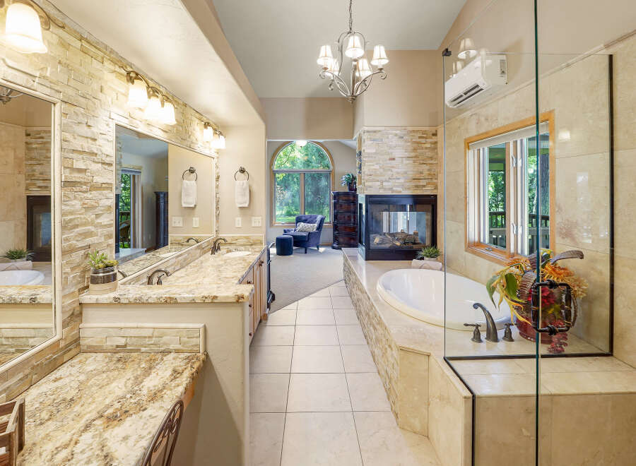 Indulge in luxury in this stunning master bathroom, featuring a spacious vanity with dual sinks and granite countertops.