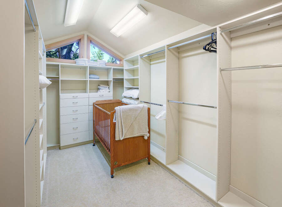 Discover this spacious walk-in closet featuring ample storage with built-in shelves and drawers, perfect for organizing your wardrobe.