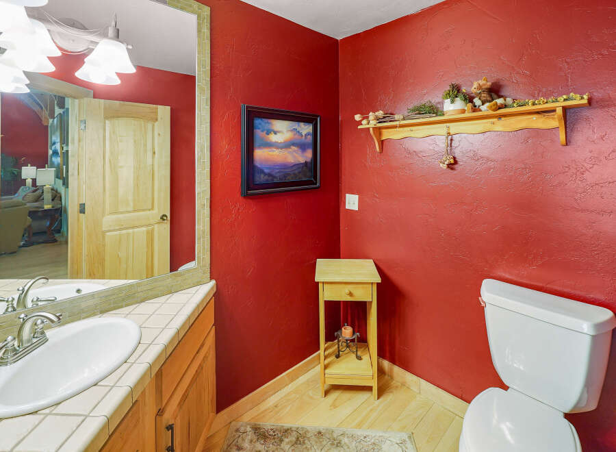 This charming bathroom features a vibrant red textured wall, creating a bold and inviting atmosphere.