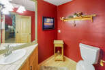 This charming bathroom features a vibrant red textured wall, creating a bold and inviting atmosphere.