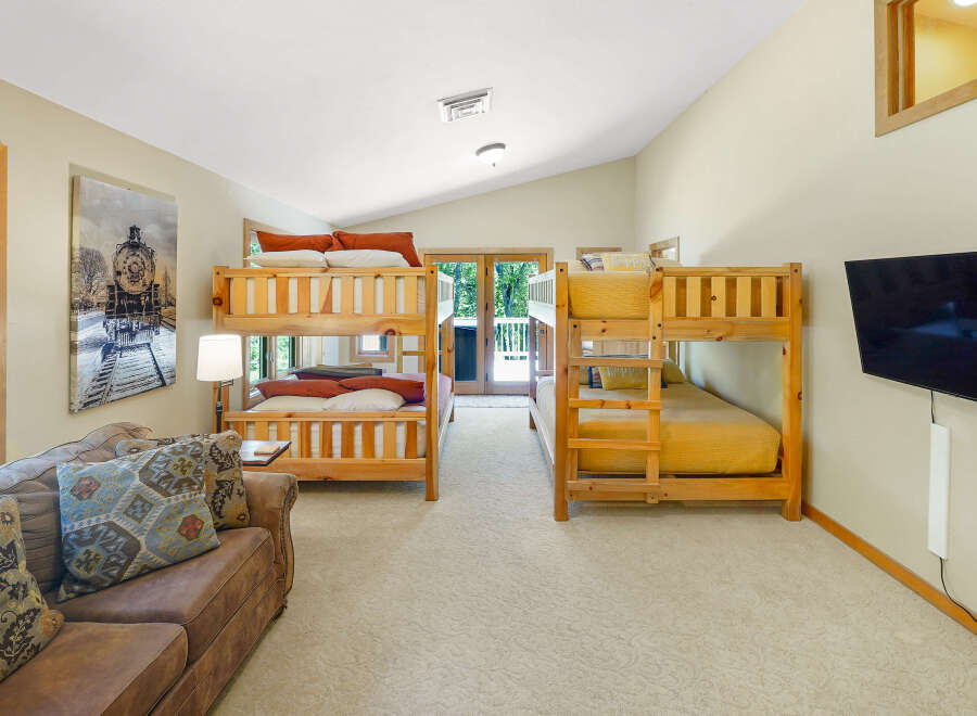 This spacious room features two sets of wooden bunk beds, perfect for accommodating multiple guests or children.