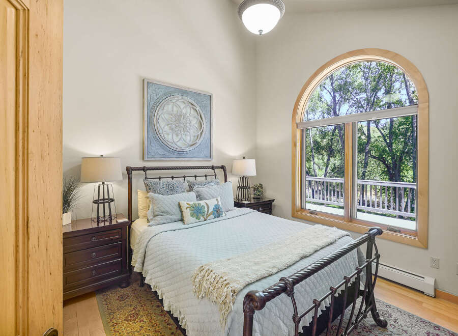 This charming bedroom features a cozy queen-size bed with a light blue quilted comforter and decorative pillows, perfect for relaxation.