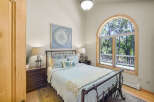 This charming bedroom features a cozy queen-size bed with a light blue quilted comforter and decorative pillows, perfect for relaxation.