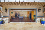 This spacious garage offers a versatile space for recreation and storage, featuring a ping pong table for entertainment and ample cabinetry for organization.