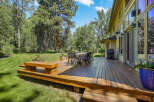 Enjoy outdoor living on this expansive wooden deck, perfect for entertaining or relaxing amidst lush greenery.