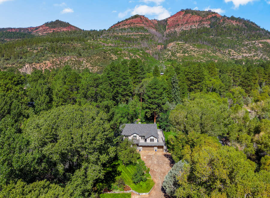 Nestled amidst lush greenery and towering trees, this stunning property offers a serene retreat with breathtaking mountain views.