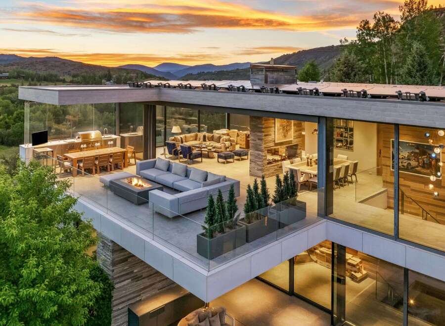 Experience luxury living with this stunning modern home featuring expansive glass walls and breathtaking mountain views.
