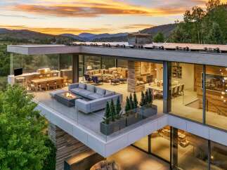 Experience luxury living with this stunning modern home featuring expansive glass walls and breathtaking mountain views.