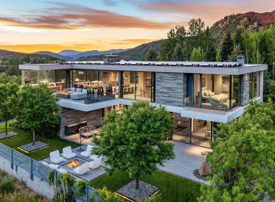 Experience luxury mountain living in this stunning modern home, featuring expansive glass walls that blur the lines between indoor and outdoor spaces.