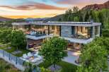 Experience luxury mountain living in this stunning modern home, featuring expansive glass walls that blur the lines between indoor and outdoor spaces.