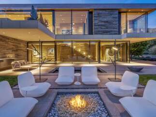 Experience luxury outdoor living with this stunning modern home featuring a sleek fire pit area perfect for evening gatherings.