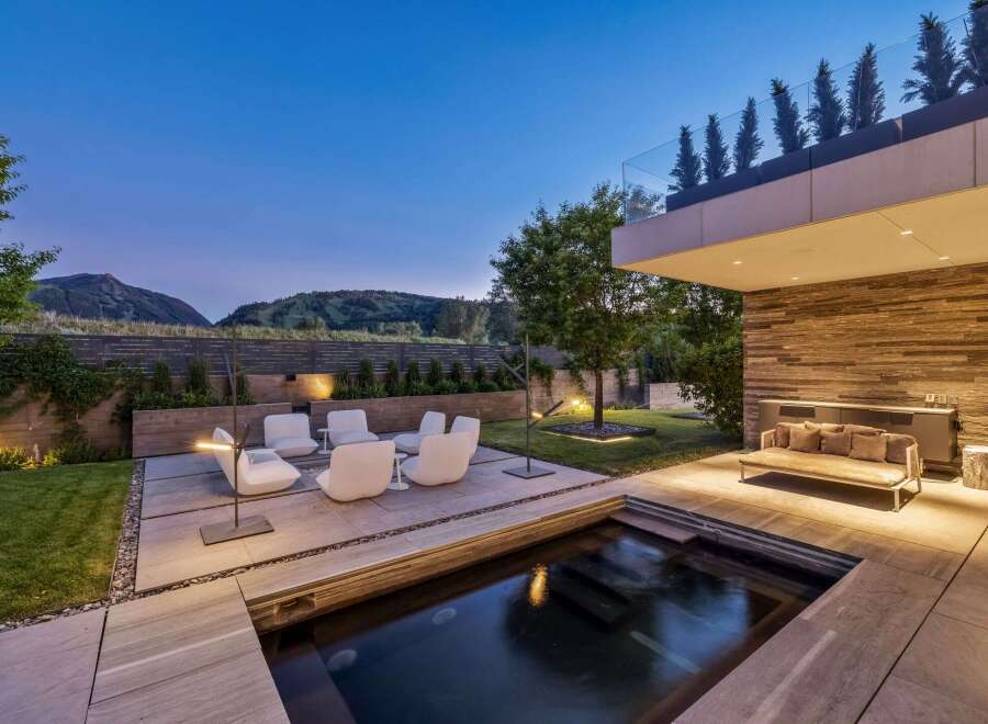 Experience luxury outdoor living with this stunning modern backyard featuring a sleek plunge pool and a sophisticated seating area.
