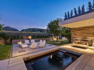 Experience luxury outdoor living with this stunning modern backyard featuring a sleek plunge pool and a sophisticated seating area.