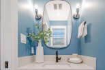 This modern bathroom features a sleek vanity with a white countertop and a matte black faucet.