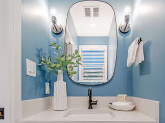This modern bathroom features a sleek vanity with a white countertop and a matte black faucet.