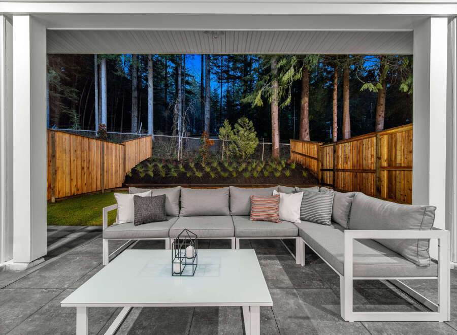Experience outdoor living at its finest with this stunning patio featuring a spacious sectional sofa and a modern coffee table.