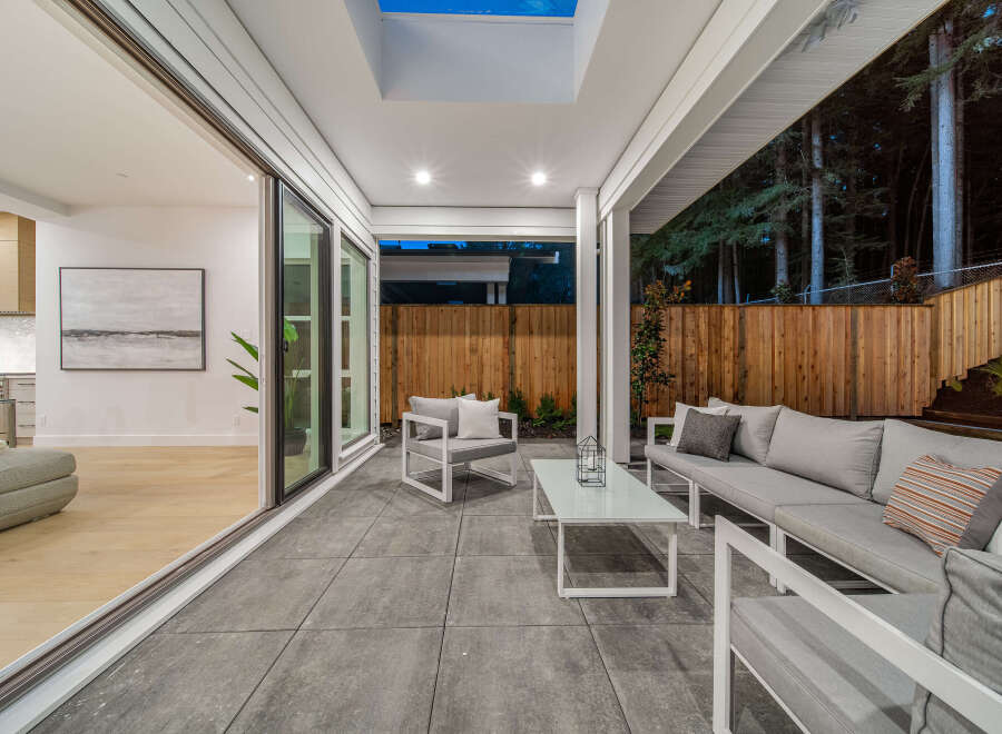 Experience seamless indoor-outdoor living with this stunning covered patio, featuring a modern outdoor seating area perfect for relaxation and entertaining.