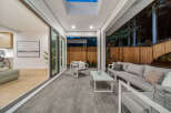 Experience seamless indoor-outdoor living with this stunning covered patio, featuring a modern outdoor seating area perfect for relaxation and entertaining.