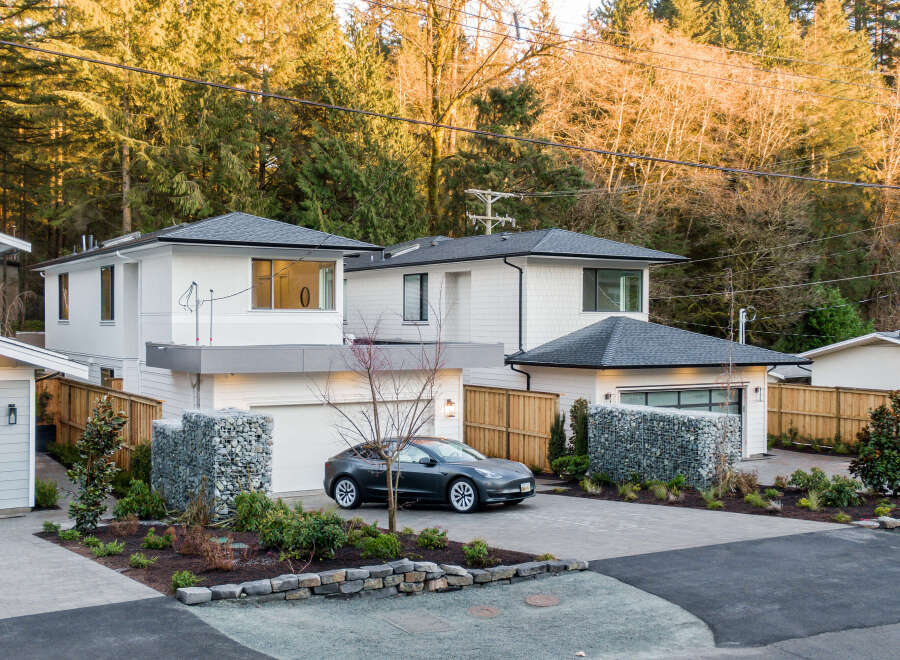 Discover modern living in this stunning new construction home, featuring a sleek Tesla parked in the driveway.