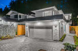Modern architecture meets natural beauty in this stunning home, featuring a sleek grey garage door and contemporary siding.