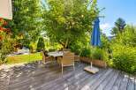 Enjoy al fresco dining on this charming wooden deck, perfect for entertaining guests or relaxing with family.