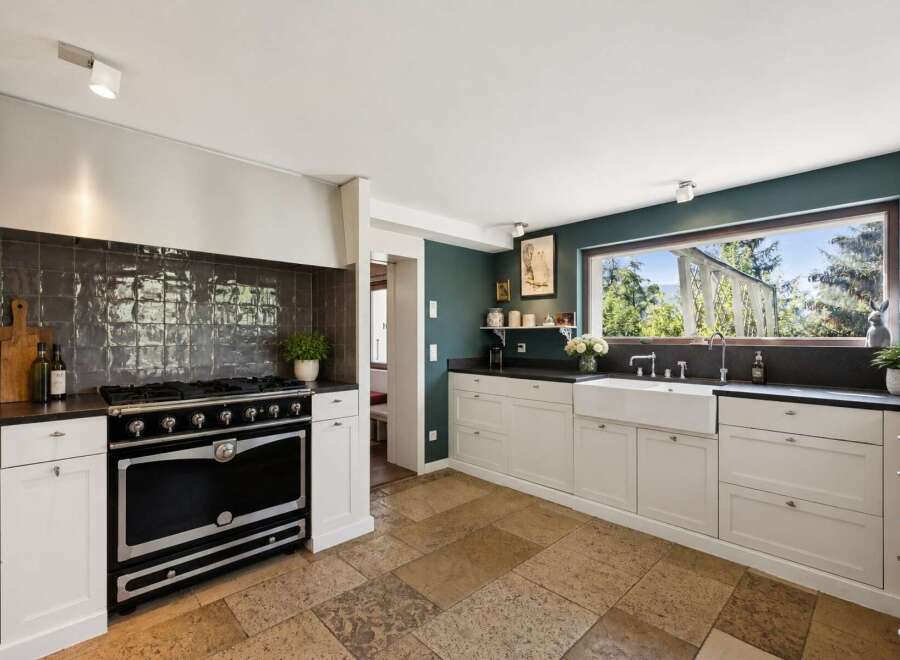 Experience the charm of this beautifully appointed kitchen, featuring a professional-grade range and a spacious farmhouse sink.