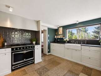 Experience the charm of this beautifully appointed kitchen, featuring a professional-grade range and a spacious farmhouse sink.