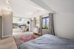 This charming bedroom features a vaulted ceiling with skylights, flooding the space with natural light.