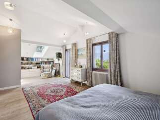 This charming bedroom features a vaulted ceiling with skylights, flooding the space with natural light.