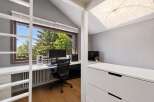 This modern home office features a large window with a scenic view of trees, providing ample natural light.