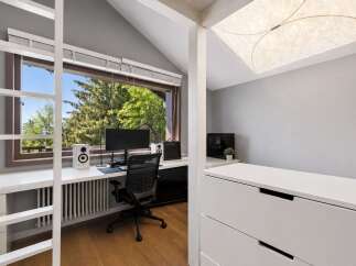 This modern home office features a large window with a scenic view of trees, providing ample natural light.