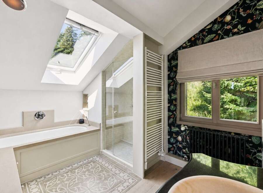 Experience luxury in this stunning bathroom featuring a deep soaking tub and a separate glass-enclosed shower, perfect for relaxation.