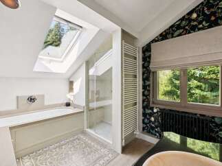Experience luxury in this stunning bathroom featuring a deep soaking tub and a separate glass-enclosed shower, perfect for relaxation.