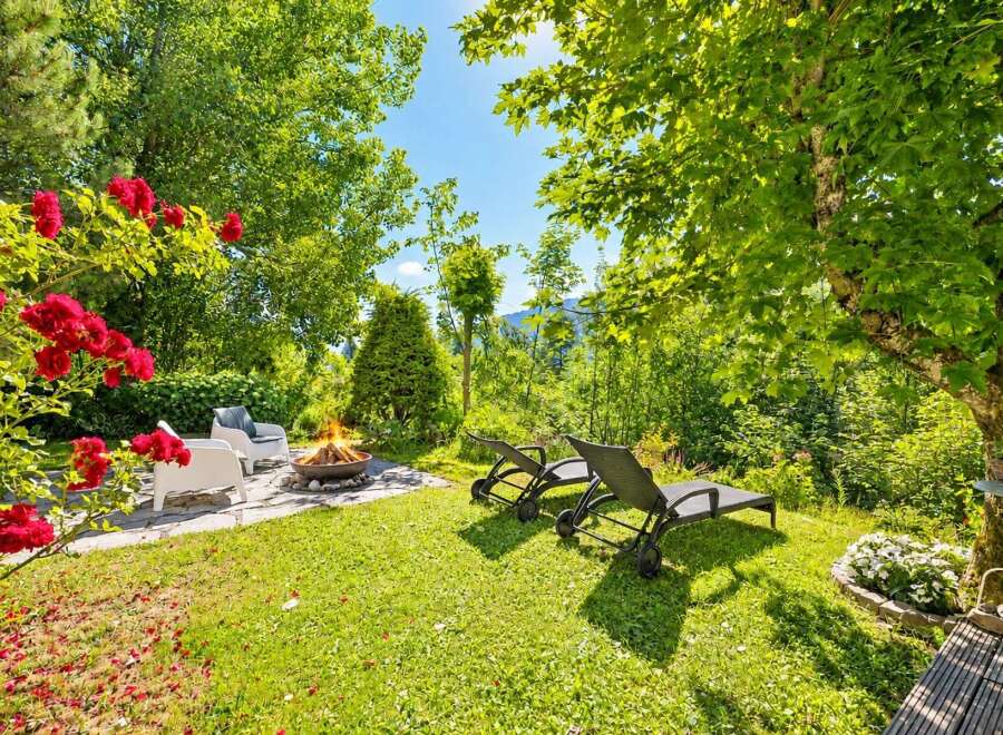 Experience ultimate relaxation in this serene backyard oasis, featuring a cozy fire pit area perfect for evening gatherings.