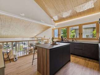 Experience modern living in this stunning attic kitchen, featuring a sleek island and ample counter space.