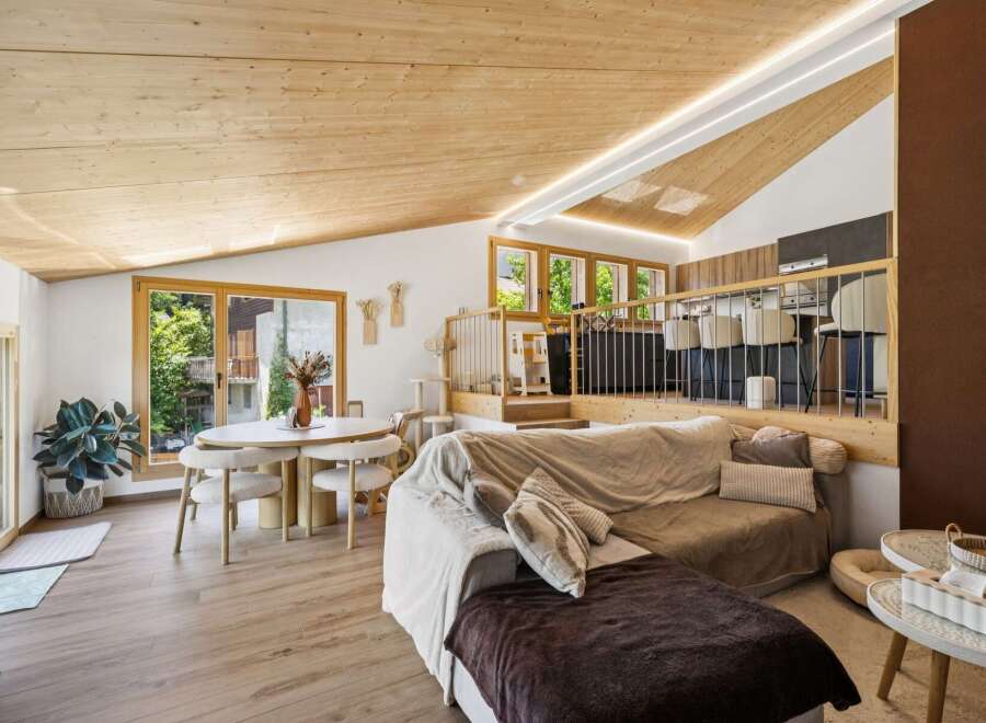 Experience modern living in this stunning loft-style apartment featuring a spacious open-plan living area with a cozy sectional sofa and a dedicated dining space.