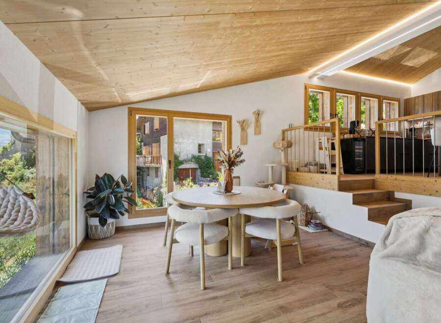 Experience modern mountain living in this stunning dining area, featuring a sleek round table with plush chairs perfect for intimate gatherings.